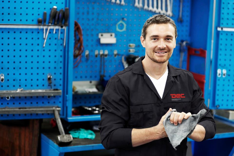 An aircraft maintenance engineer in DEC-branded overalls in the workshop